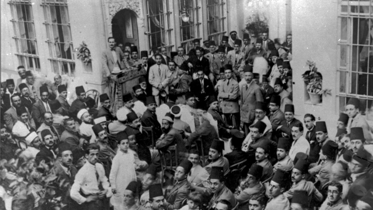 Schwarz weiß Bild: Blick von oben auf eine Versammlung von Männern.