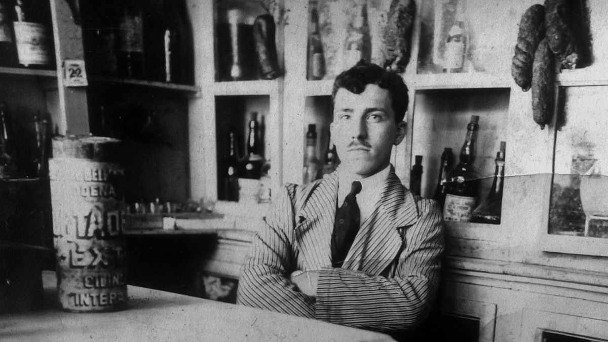 Schwarz-weiß Bild: Mann im Anzug sitzt in einem Laden.