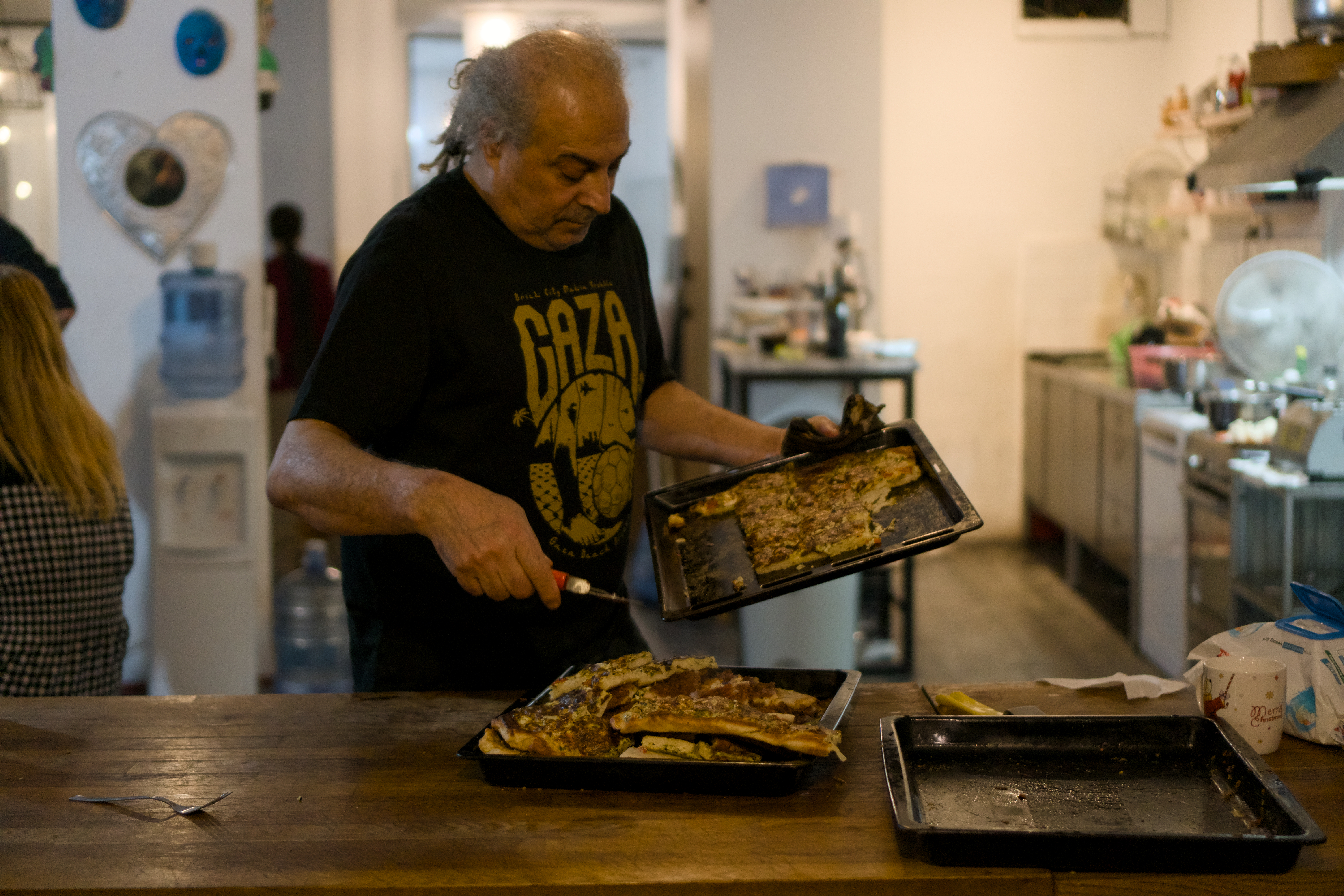 A man is distributing food in a kitchen.