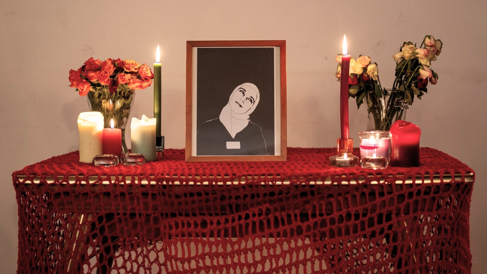 Ein Tisch mit einem Foto und Kerzen. 