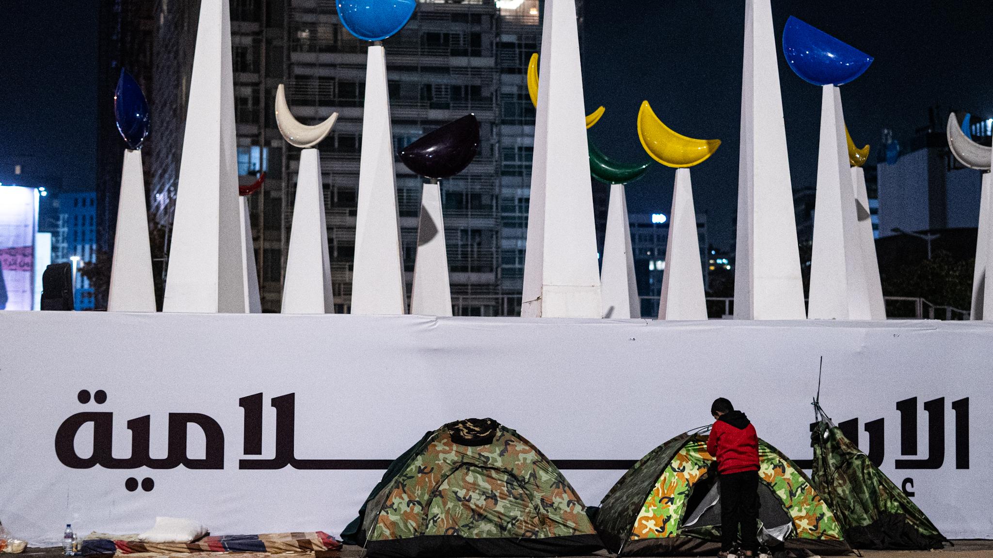 Tents in front of a large sign and Ramadan decorations.