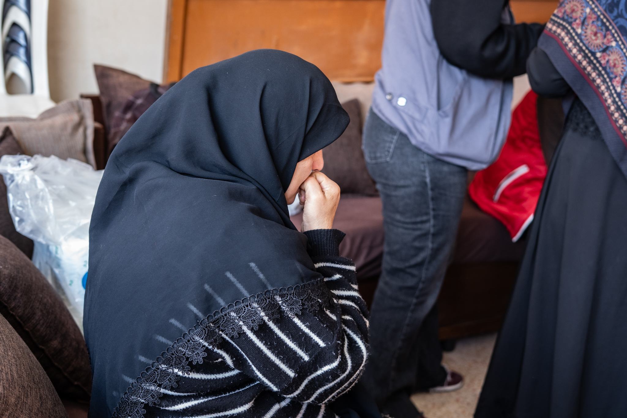 A seated woman, facing away from the camera.