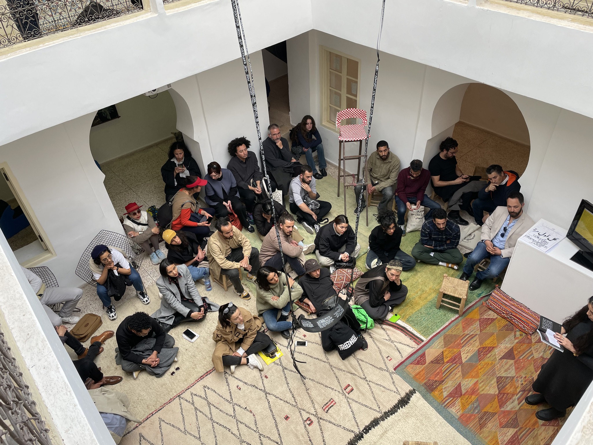 A group of people watch a presentation, photographed from above.