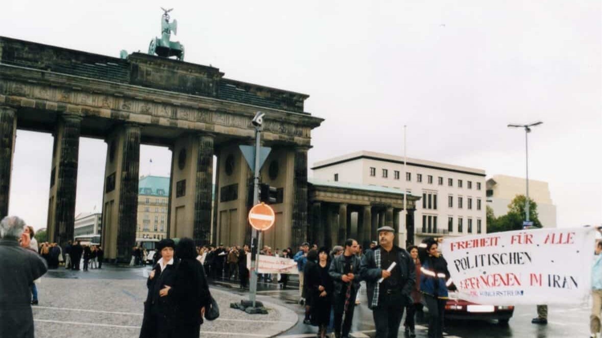Ein Protestzug durch das Brandenburger Tor mit einem Transparent mit der Aufschrift "Freiheit für alle politischen Gefangenen im Iran"