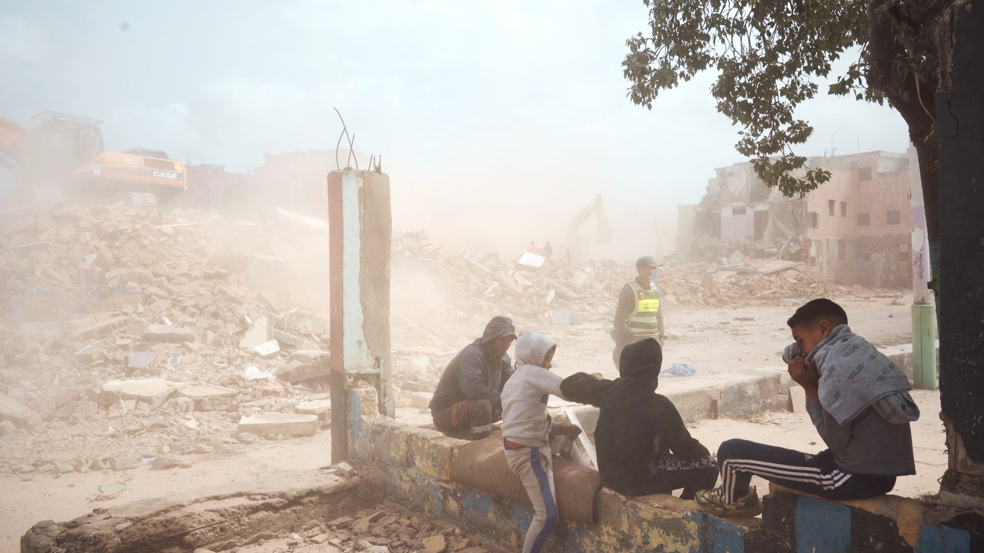 Young men watch the demolition of home. (Photo: Yassine Toumi)