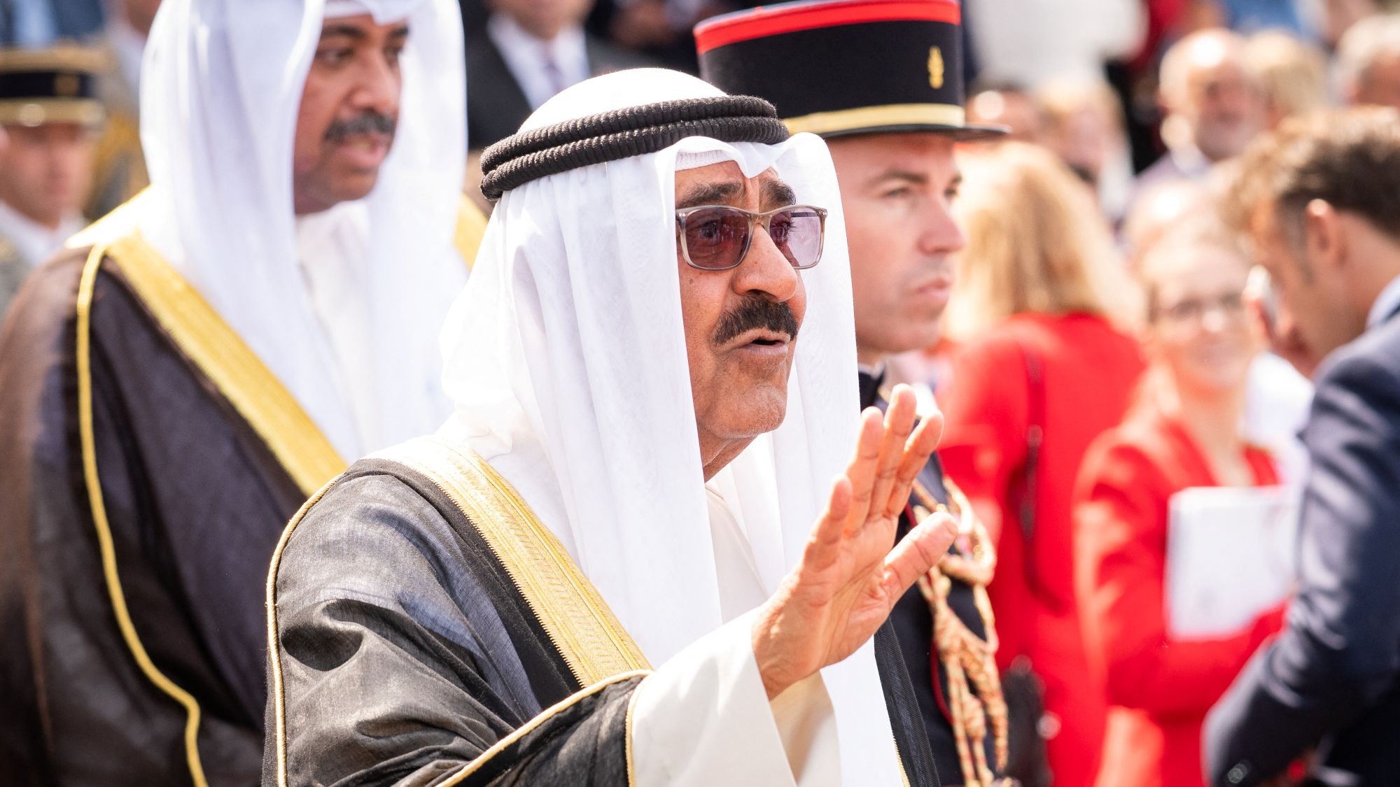 Der Emir von Kuwait in langem Gewand und weißem Kopftuch grüßt die Menge.