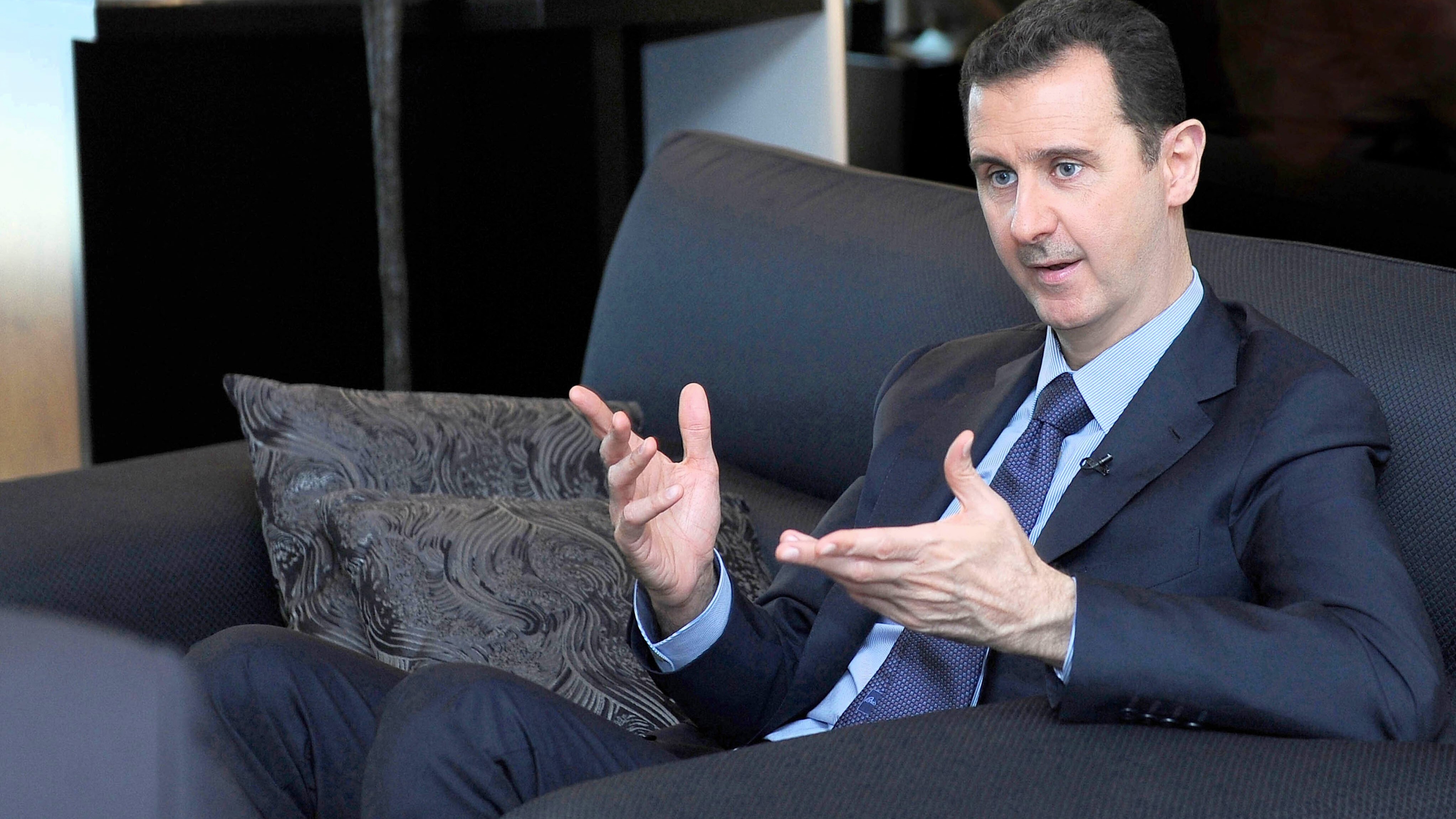 Former Syrian President Bashar Assad gestures as he speaks during an interview with a Russian newspaper, in Damascus, Syria, Aug. 26, 2013. 