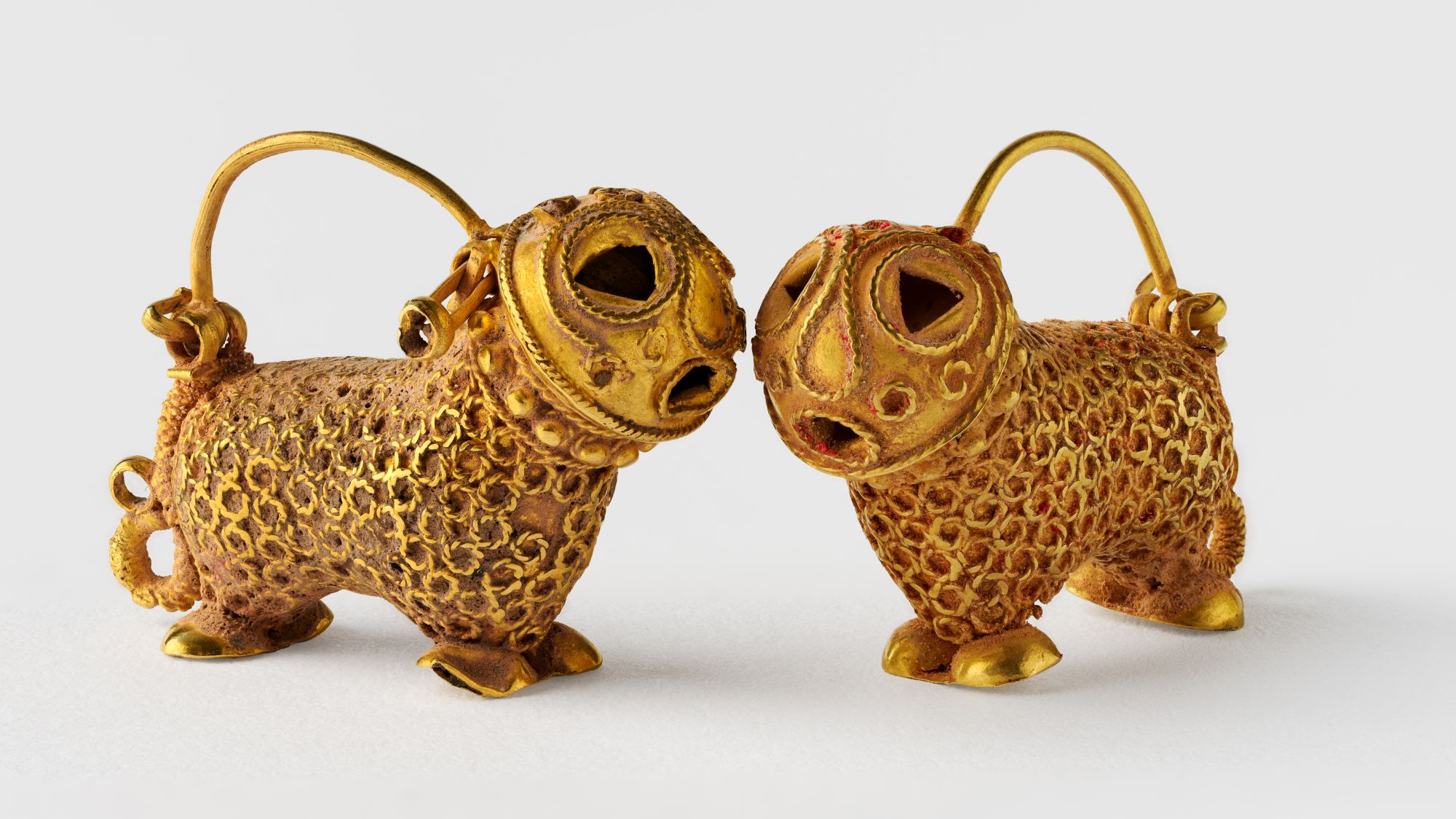 Nahaufnahme zweier goldener Ohrringe in Katzenform.