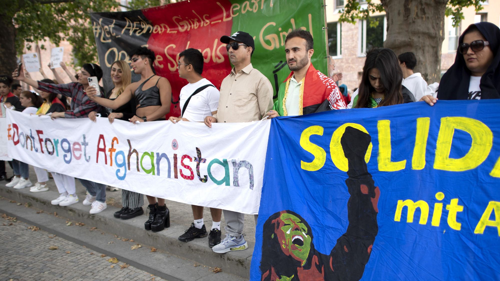 A group of people are holding banners bearing the words "Don't Forget Afghanistan"