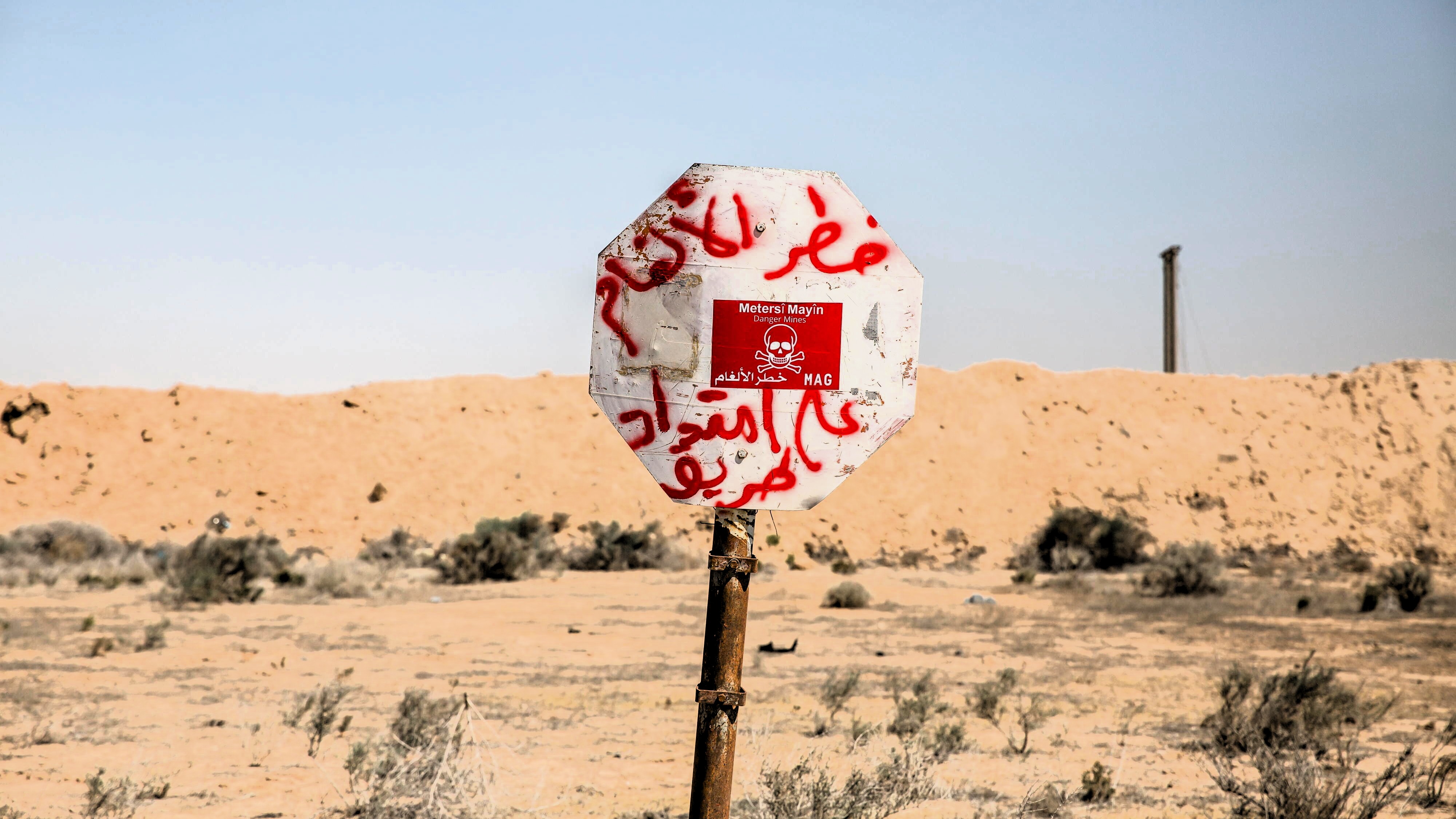 (Photo: picture alliance / Sipa USA | SOPA Images) لافتة في بداية حقل ألغام مكتوب عليه باللغة العربية.