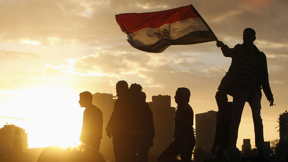 A protester opposing Egyptian President Mohamed Mursi holds an Egyptian flag as he stands on Kasr El Nile bridge, which leads to Tahrir Square in Cairo, February 1, 2013 (photo: Reuters/Mohamed Abd El Ghany)