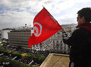 A protester waves the Tunisian flag as he watches a demonstration in Tunis (AP/dapd)