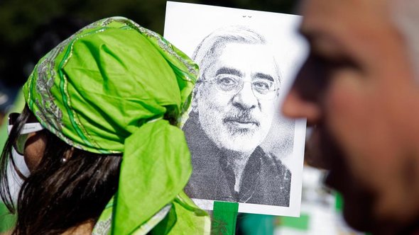 Green Revolution activists hold up a poster of Mir-Hossein Moussavi, leader of the movement (photo: AP)
