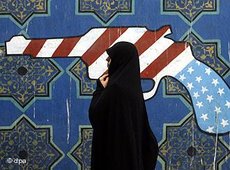 A woman walking past a mural of a pistol in the colours of the American flag (photo: dpa)