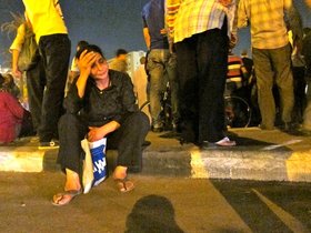 A woman sitting on the sidewalk after the violence on Sunday (photo: Joseph Mayton)