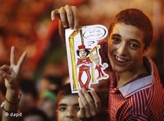 Teenage boy holds up a cartoon of Gaddafi at the gallows (photo: dapd)