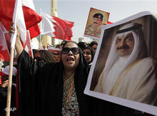 Portraits of Bahraini Prime Minister Khalifa bin Salman Al Khalifa and King Hamad bin Isa Al Khalifa are being held up during a pro-government demonstration (photo: Hassan Ammar/AP)