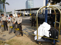 Police officers stand guard outside the Ritz-Carlton hotel after an explosion went off there in Jakarta, Indonesia, Friday, July 17, 2009 (photo: AP)