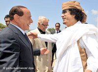 Silvio Berlusconi greets Muammar al-Gaddafi (photo: dpa)