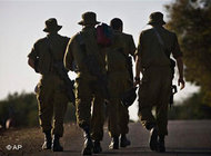Israeli soldiers walk near Israel's border with the Gaza Strip,  27 January 2009 (photo: AP)