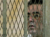 Ayman Nour, seen through the bars of the defendant's dock (photo: AP)