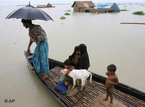 A family leaves their submerged house on a country boat through flood waters in India (photo: AP)