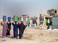 Four women carry water to their houses in the Cairo settlement of Manshiet Nasr (photo: AP)