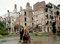 Local residents walk past destroyed buildings in Grozny, Chechnya (photo: AP)