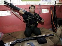 A leader of the Muslim Thai community displays his defence weapons (photo: AP)