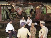 Police investigate near a train destroyed by a bomb blast in Bombay (photo: AP)