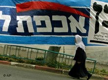 A Druze Arab walks past an election campaign poster (photo: AP)