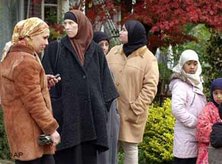 Women and children wait outside a Muslim elementary school in Eindhoven, November 2004. An explosion blew the door and shattered windows across the street (photo: AP)