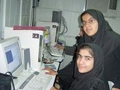 Two women with headscarf at a PC workstation (photo: Irin News)