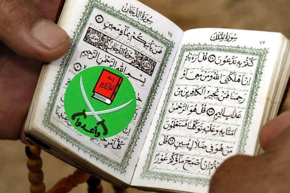 رجل يقرأ القرآن الكريم ويستخدم شعار الإخوان كعلامة لآخر صفحة بلغ قراءتها. د ب أ  