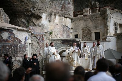 Priests in white vestments and black and purple headdresses surrounded a chanting Patriarch Bartholomew in the Panagia Soumela Monastery (photo: Iason Athanasiadis)