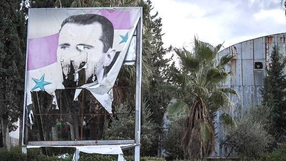 صورة ممزقة لبشار الأسد في حلب، ديسمبر 2012 . أ ب