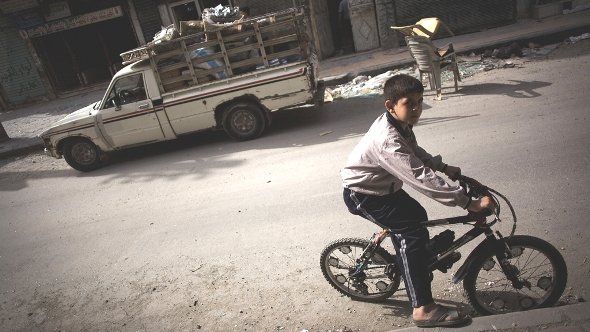 In this Saturday, Oct. 20, 2012 photo, a Syrian boy rides his bike in Karma Jabl district in Aleppo, Syria (photo: Manu Brabo/AP/dapd)