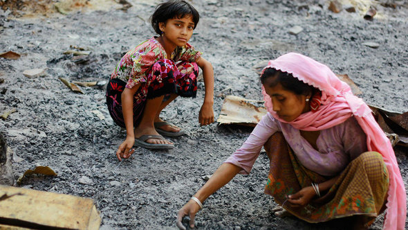 Members of a Muslim Rohingya family gather at the ruins of their home, which was burnt in recent violence, in Mrauk Oo township October 29, 2012 (photo: Reuters)