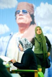 Female students in Libya in front of a poster of Col Gaddafi (photo: AP)