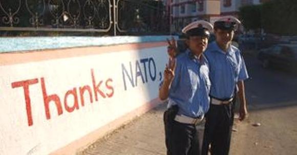 Polizisten vor einer Mauer mit der Aufschrift 'Danke Nato' in Libyen; Foto: DW Polizisten vor einer Mauer mit der Aufschrift 'Danke Nato' in Libyen; Foto: DW