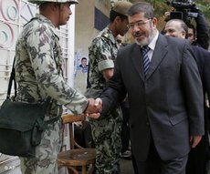 Muslim Brotherhood spokesman Mohammed Morsi shakes hands with a solider (photo: AP)