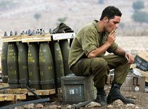 Ein israelischer Soldat bewacht Artilleriemunition an der Grenze zum Libanon; Foto: DW