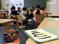 A file of teaching materials with the word Allah written in Arabic on the front lying on a table in a classroom (photo: dpa)