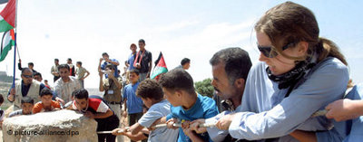 إسرائيليون وفلسطينيون يقومون بإزالة بعض المعوقات التي تستخدم للحواجز العسكرية في مدينة الخليل،الصورة: د.ب.ا