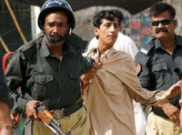 رجال شرطة يعتقلون متظاهر في كراتشي، الصورة: أ ب