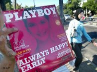 A vendor shows Indonesian version of Playboy magazine to passing motorists as a Muslim woman walks past by on a street in Jakarta, 7 April 2006 (photo: AP) 