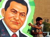 عامل مصري يُعد إحدى مُلصقات الرئيس المصري محمد حسني مبارك، قبيل إجراء الانتخابات الرئاسية الأولى من نوعها في مصر، أغسطس 2005، الصورة: أ ب