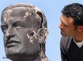 لبناني ينظر إلى تمثال حافظ الأسد المتضرر من الاحتجاجات المعادية لسوريا، الصورة: أ ب