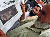 باكستانيون في لندن يقرؤون صحيفة، الصورة: أ ب