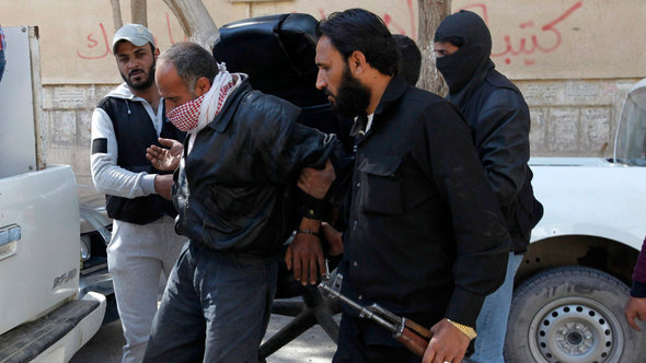 مجموعة من جبهة النصرة تلقي القبض على أحد الأشخاص في الرقة. رويترز